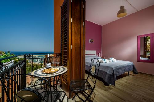 a room with a table and a balcony with a view of the ocean at Antico Canale in Castellammare del Golfo