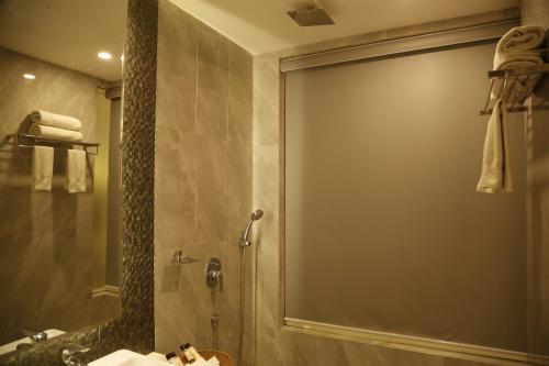 a bathroom with a shower with a sink and a mirror at Hotel Orange in Agra