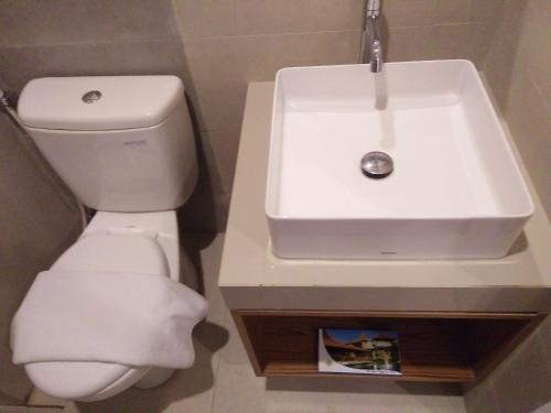 a bathroom with a white sink and a toilet at Java Village Resort by HOMEE Yogyakarta in Yogyakarta