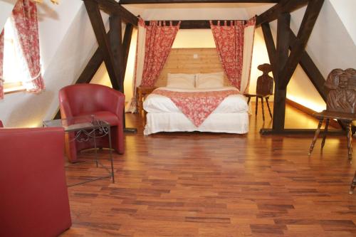 a bedroom with a bed and a chair in a attic at Auberge du Rempart in Eguisheim