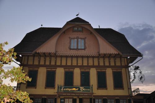 a building with a roof with a sign on it at Hotel Bären in Sumiswald