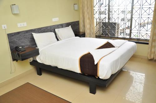 a bedroom with a large bed in a room at Hotel Rajam in Kanyakumari