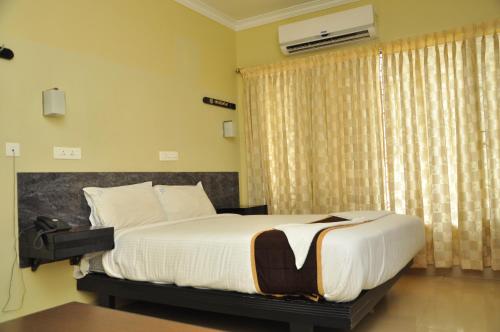 A bed or beds in a room at Hotel Rajam