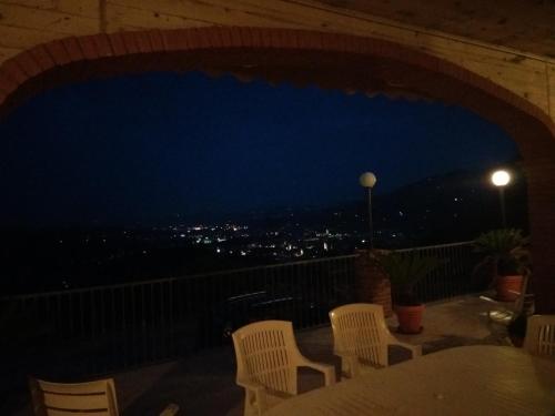 a table and chairs on a balcony at night at Mimì e Cocò Country House in Ascoli Piceno