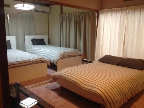 pokój z 2 łóżkami w pokoju w obiekcie Share House on the Hill w mieście Jokohama