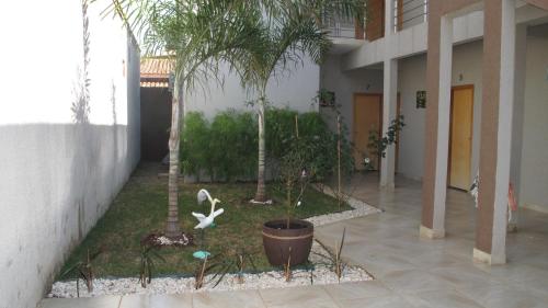 a courtyard with palm trees and plants in a building at Pousada Flor Dos Ipês in Trindade