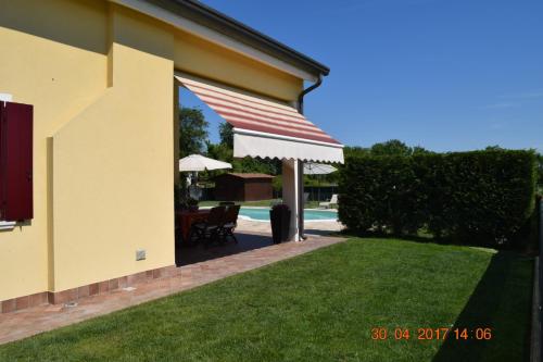 a patio with an awning on the side of a house at Villa Posta Vecchia in Loreo