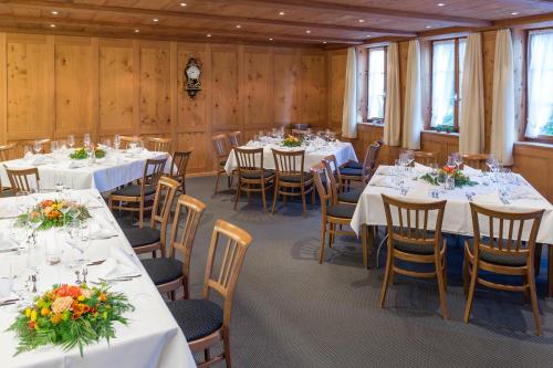 a conference room with tables and chairs with flowers on them at Hotel Bären in Sumiswald