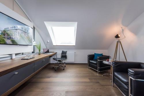 an office with a tv and two chairs and a desk at SEEhotel Friedrichshafen in Friedrichshafen