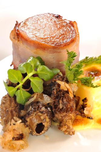 a plate of food with a piece of meat and vegetables at Hotel Krone Langenegg in Langenegg