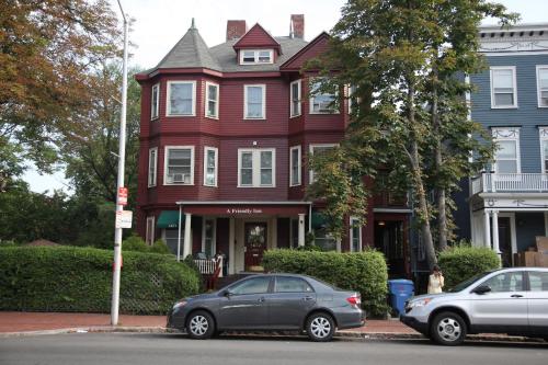 a red house with two cars parked in front of it at A Friendly Inn at Harvard in Cambridge