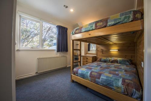 a bedroom with a bunk bed and a ladder at TERAMA Ski Lodge in Mount Buller