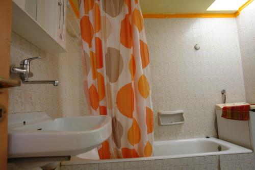 a bathroom with a sink and a shower curtain at Earini Rooms And Apartments in Chania