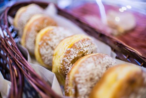 a basket of donuts with powdered sugar on it at Hotel Fürdőház in Nyíregyháza