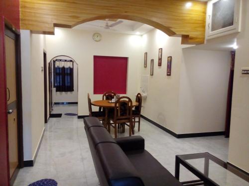 a living room with a couch and a table at Barnabas Homestay in Thanjāvūr