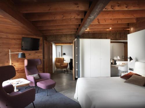 1 Schlafzimmer mit einem Bett und 2 Stühlen sowie einem TV in der Unterkunft Mont-Sant in Xàtiva