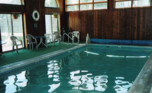a swimming pool with chairs and a table and windows at Austrian Haus Lodge in West Dover