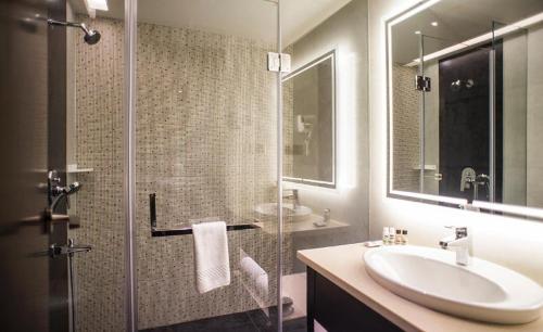 馬圖拉的住宿－布里奇瓦希蘭德斯酒店，一间带水槽和玻璃淋浴的浴室