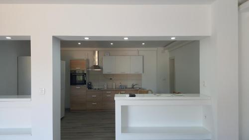a kitchen with white cabinets and a white counter top at Apartments Nogic in Peroj
