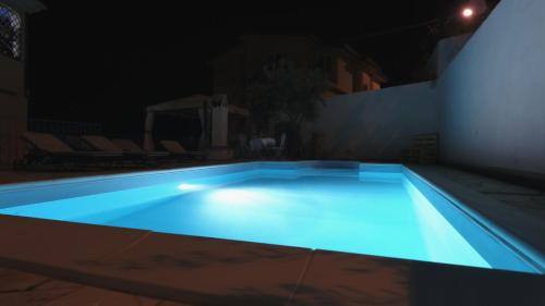 a swimming pool at night with blue lighting at B&B Rita and Family in Loceri