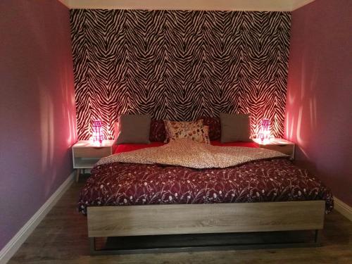 a bedroom with a bed with red lights on it at Apartment Obelix in Holtorf