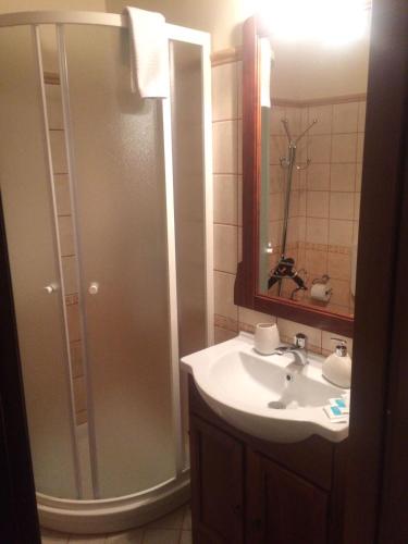 a bathroom with a sink and a shower with a mirror at B&B San Cristofero in Valguarnera Caropepe