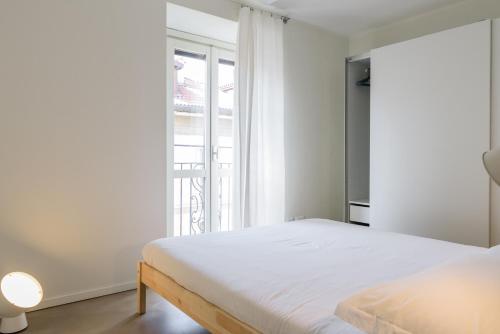a bedroom with a bed and a large window at Palermo Flexyrent Apartment in Milan