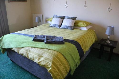 a bedroom with a large bed with two towels on it at Grysbok Self Catering Accommodation in Oudtshoorn