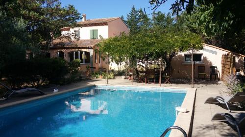 uma piscina em frente a uma casa em Le clos des olivettes em Sainte-Croix-de-Quintillargues