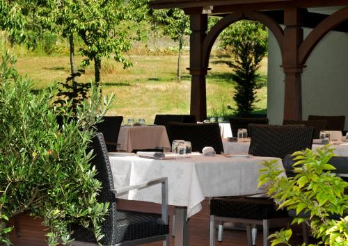a table with a white tablecloth and chairs in avisor at Logis Hotel Le Parc & Spa in Saint-Hippolyte
