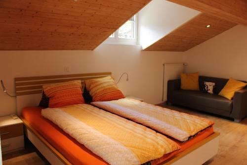 a large bed in a room with a couch at Haus Dorf 7 in Saas-Grund