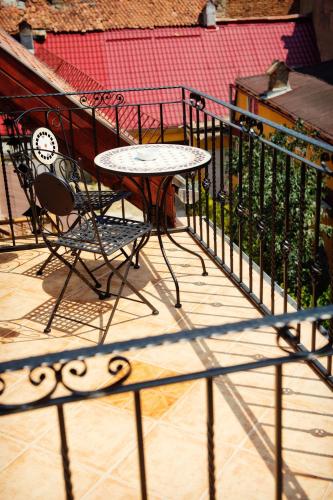 a table and chairs on a balcony with a fence at Casa Wagner in Braşov