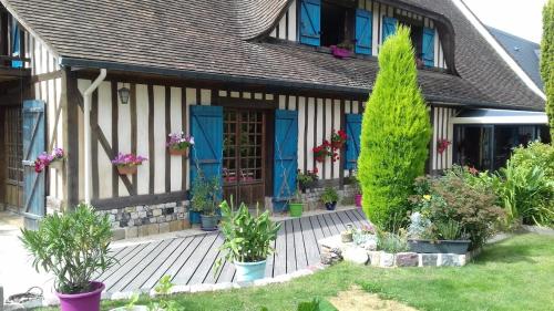 a house with plants in front of it at Chez Catherine - Chaumière Normande in Theuville-aux-Maillots