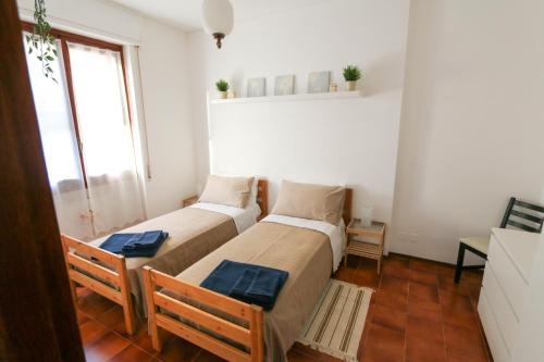 two beds in a small room with a window at Casa Bonita in Sanremo