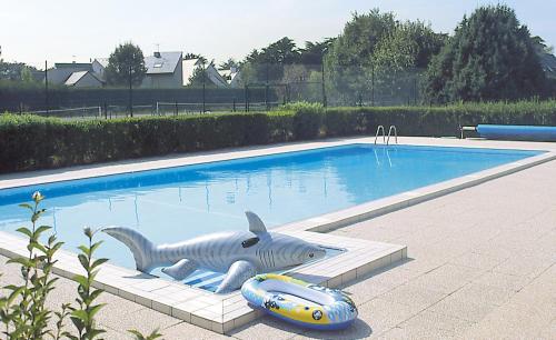 una estatua de tiburón sentada junto a una piscina en Lagrange Vacances Les Maisonnettes, en Le Pouliguen