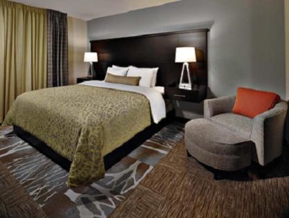 Habitación de hotel con cama y silla en Staybridge Suites Longview, an IHG Hotel, en Longview