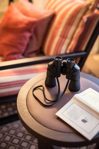 a pair of binoculars sitting on a table with a book at Severin's Resort & Spa in Keitum