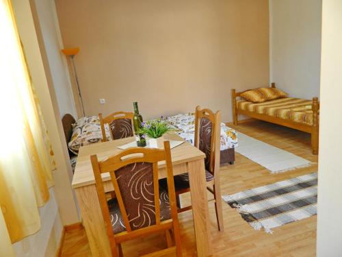 una sala da pranzo con tavolo, sedie e divano di Apartmani Kosjerina a Trebinje