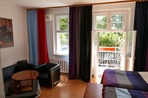 een slaapkamer met een bed, een stoel en een raam bij Rooms Bytom in Bytom