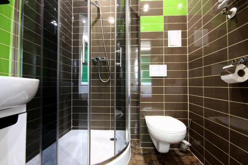 a bathroom with a toilet and a glass shower at Pensjonat Pod Kasztanami in Głogów