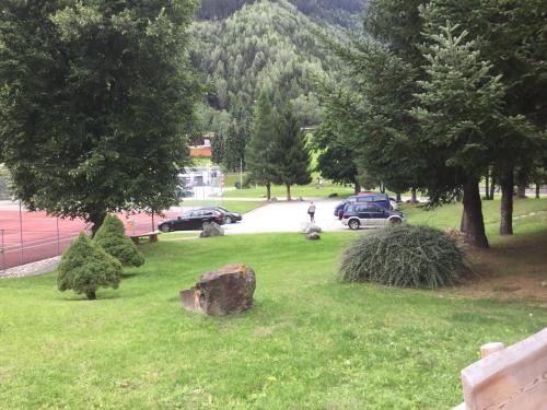 a park with cars parked on a road with trees at Disentis in Disentis