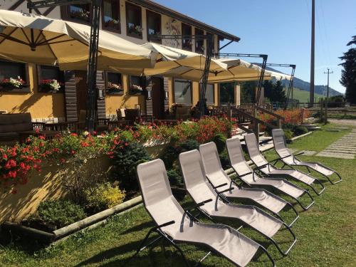 a row of white chairs in front of a building at La capr'allegra in Gallio