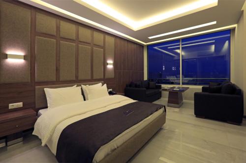 a bedroom with a large bed and a large window at Ibiza Hotel in Jounieh