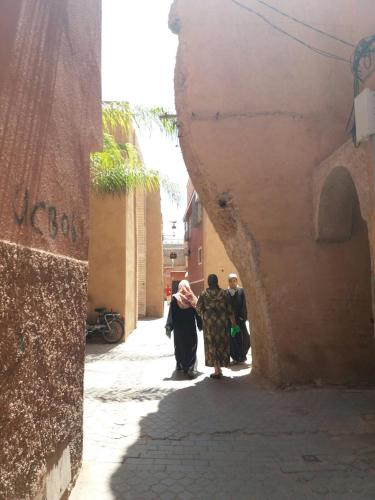 a group of people walking down a alley at Riad Charme d'Orient Adults Only in Marrakech