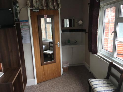 um quarto com uma porta com uma cadeira e uma janela em South Fork Guest House em Leicester