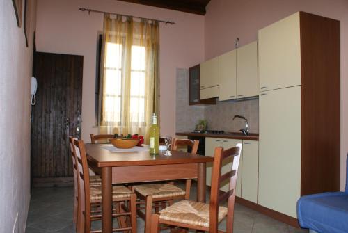 カステッランマーレ・デル・ゴルフォにあるNadirのキッチン(テーブル、椅子付)、キッチン(白いキャビネット付)