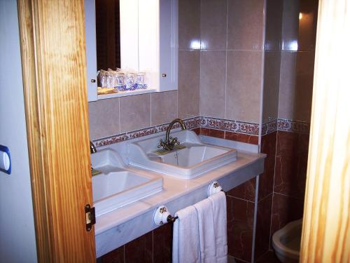 La salle de bains est pourvue d'un lavabo et d'un miroir. dans l'établissement Castillo Lanjaron, à Lanjarón