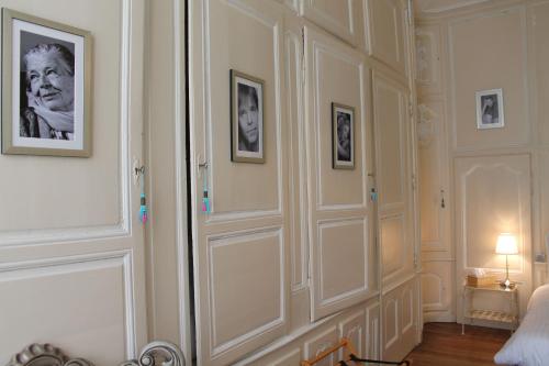a bedroom with white walls and pictures on the wall at Châtellerie De Schoebeque in Cassel