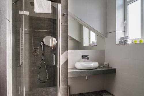 uma casa de banho com um chuveiro e um lavatório. em Hotel Wilga em Cracóvia