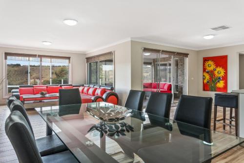 a dining room with a glass table and chairs at Bulla Hill Villas - Spacious Group Accommodation, 5 Min to Airport in Bulla